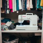 A cluttered closet with fabric scraps, sewing machine, and DIY tools. Garments are being transformed into new pieces through various zero waste techniques